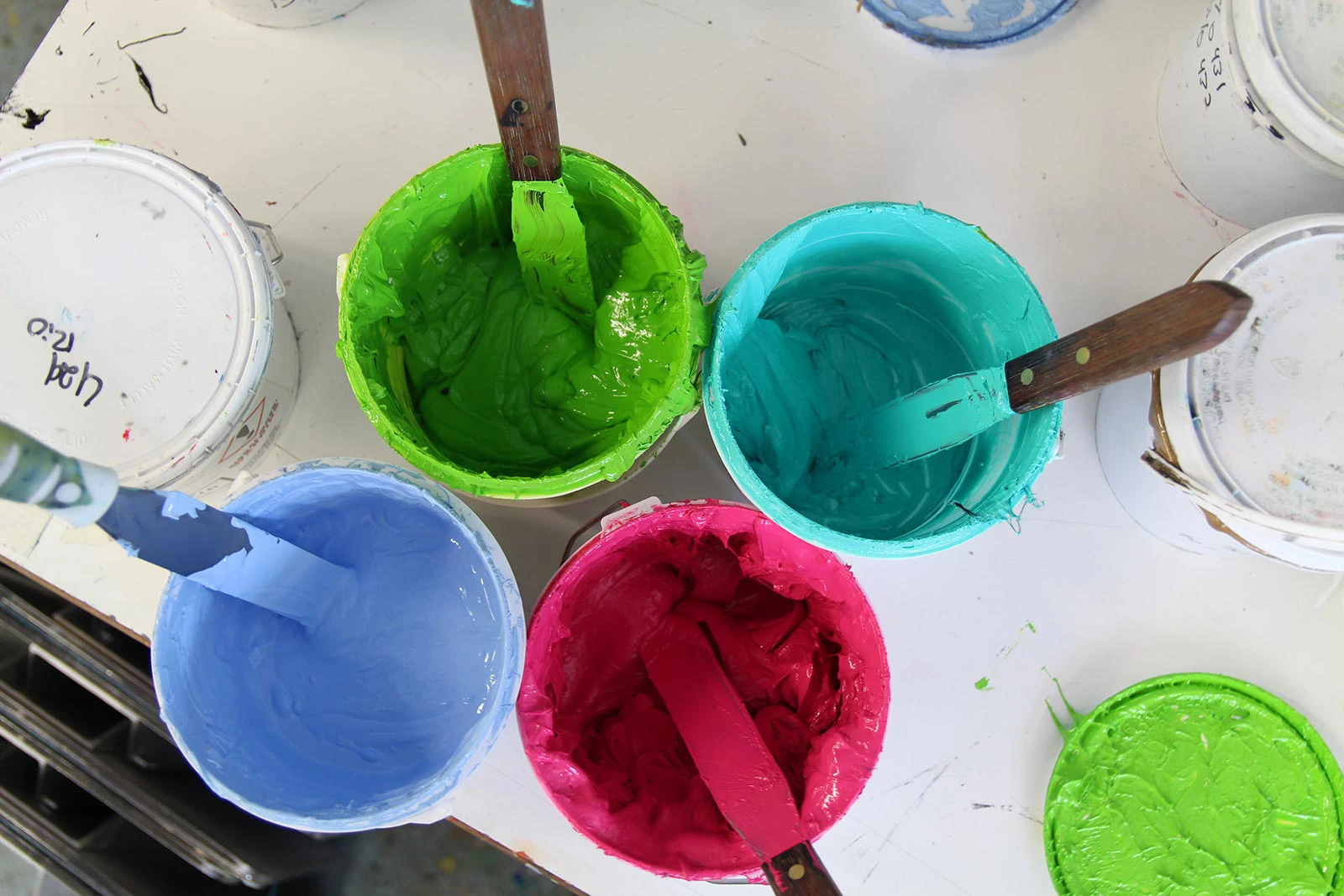 Green, Teal, Blue and Pink Screen Printing inks in tubs
