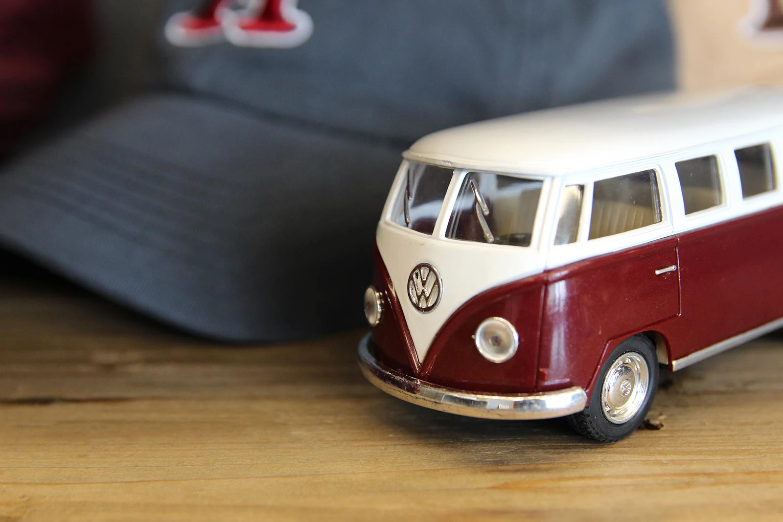 Volkswagon Bus toy next to a baseball cap